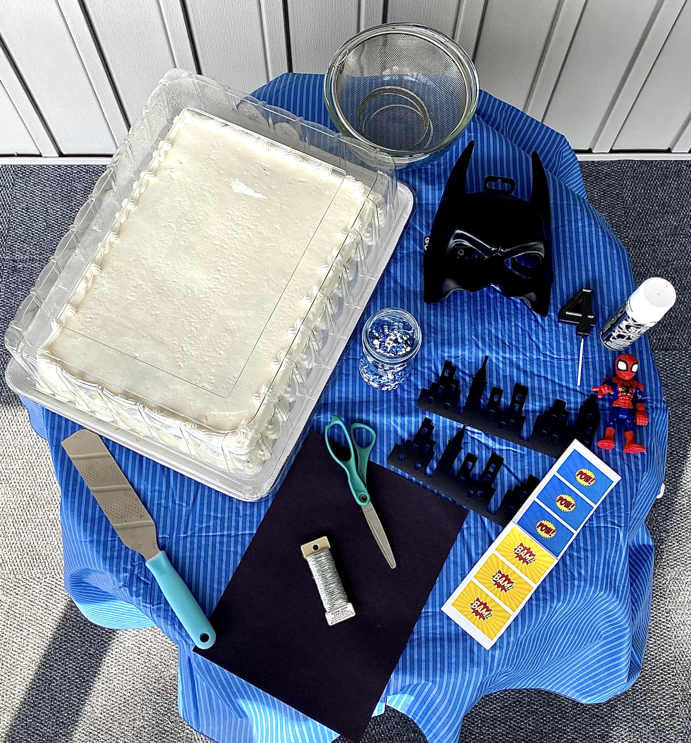 My supplies for my DIY Batman cake, you can see the quantity of the cake that will soon be cut and covered in sprinkles