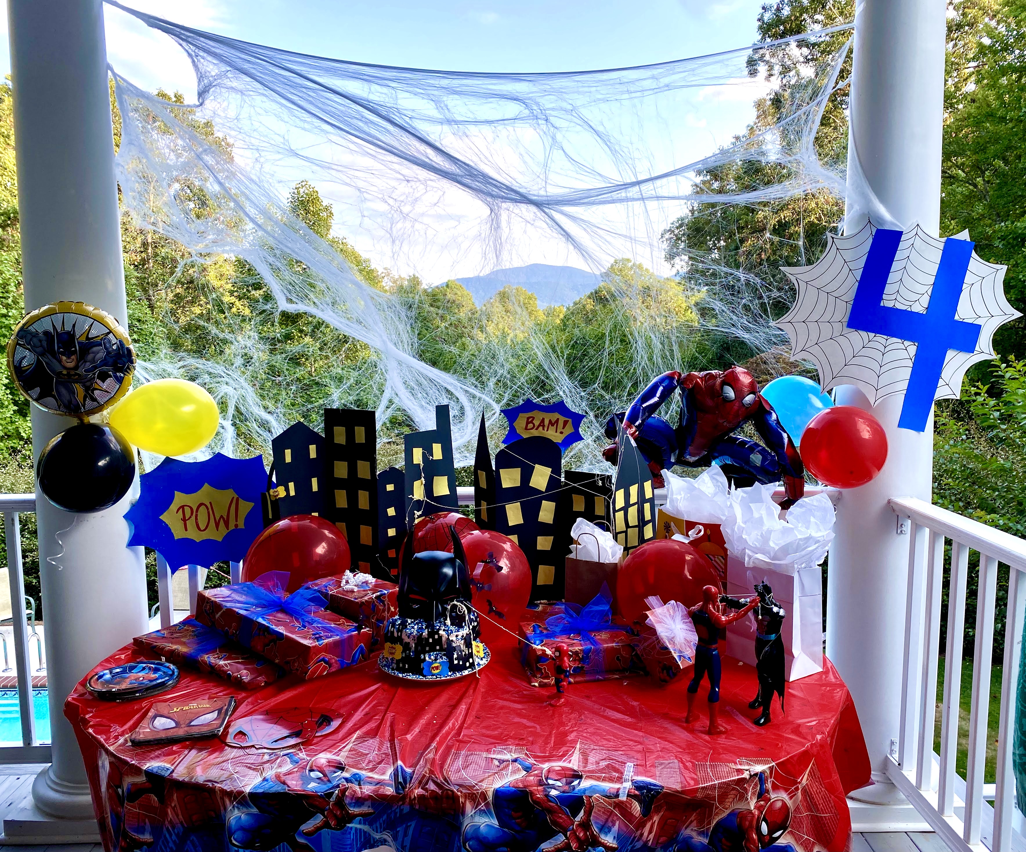 Batman birthday cake along with the city skyline and yellow windows. 